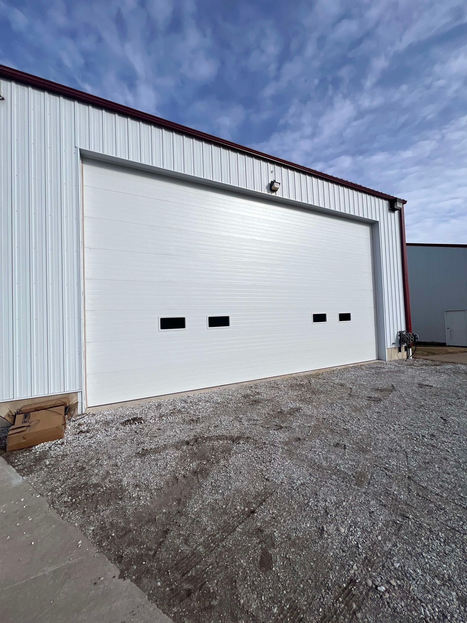A large white garage door is sitting in front of a building.