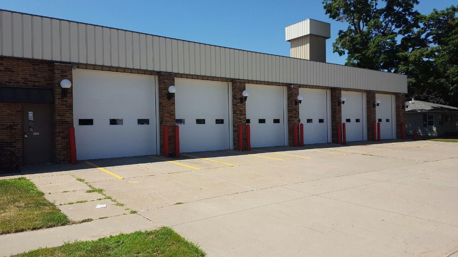 A row of garage doors are lined up in front of a building.