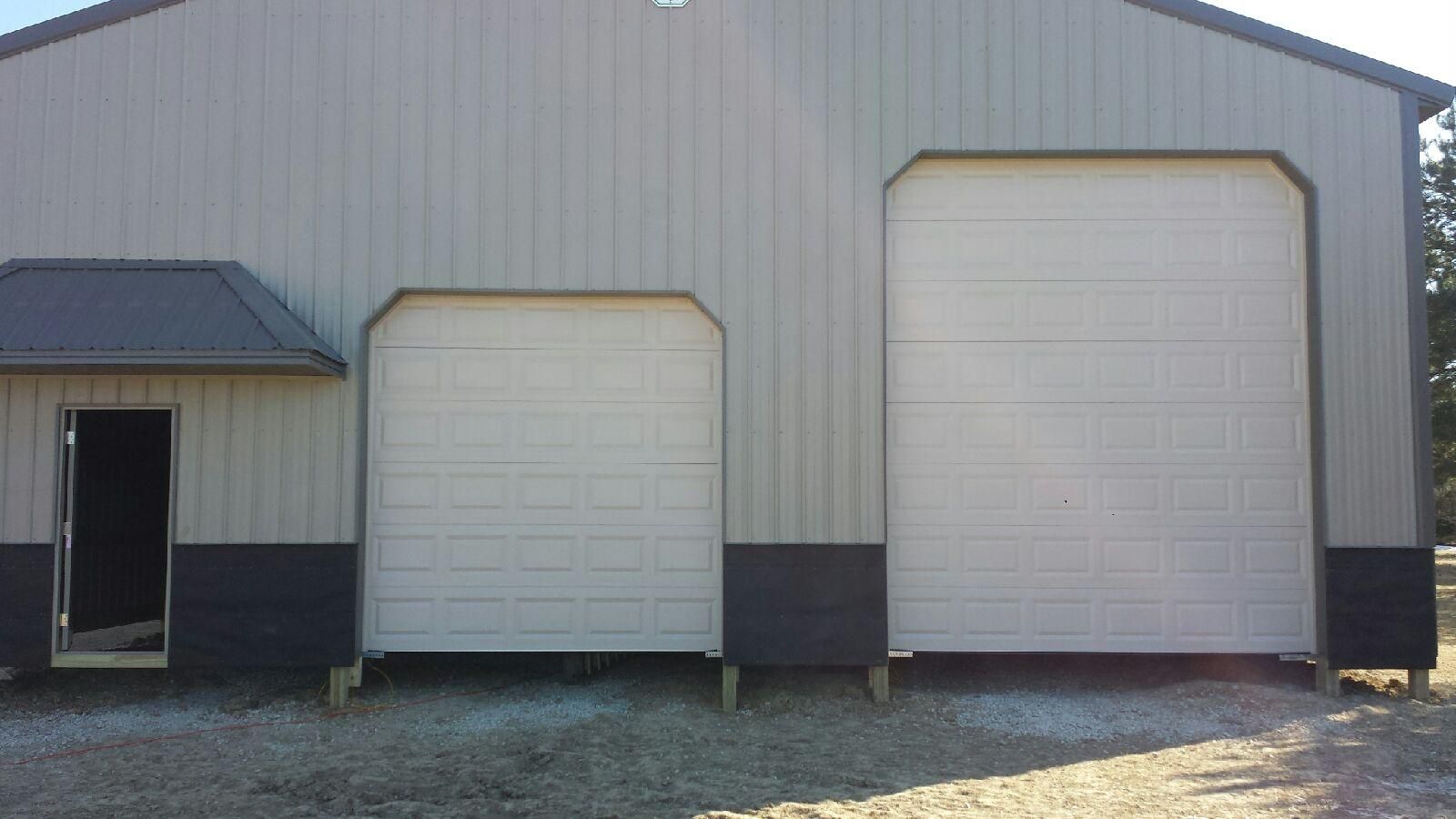 There are two garage doors on the side of a building.