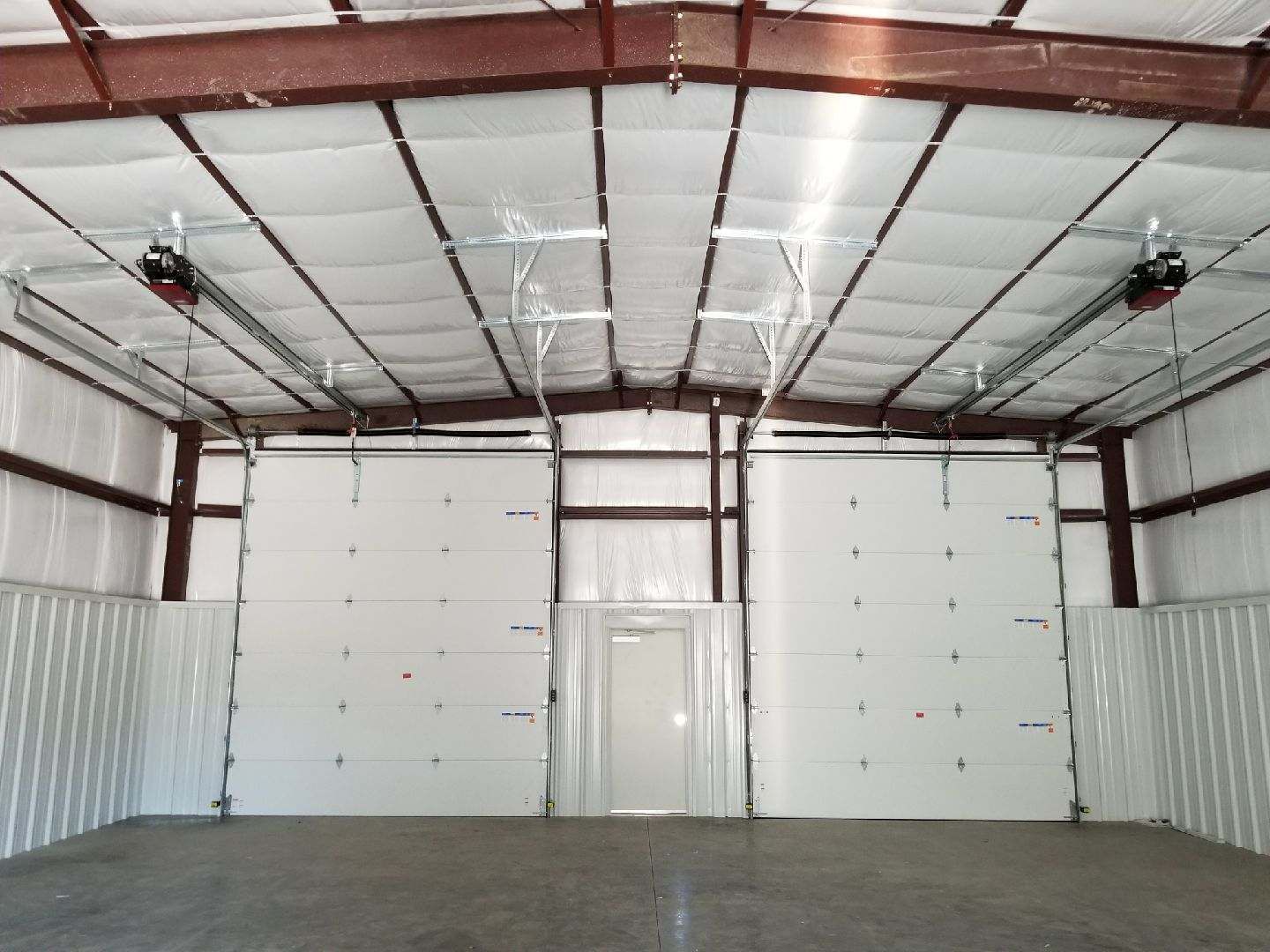 A large empty garage with a lot of doors
