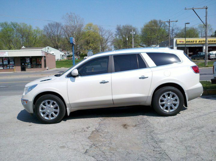 White SUV parked on a street near storefronts on a sunny day
