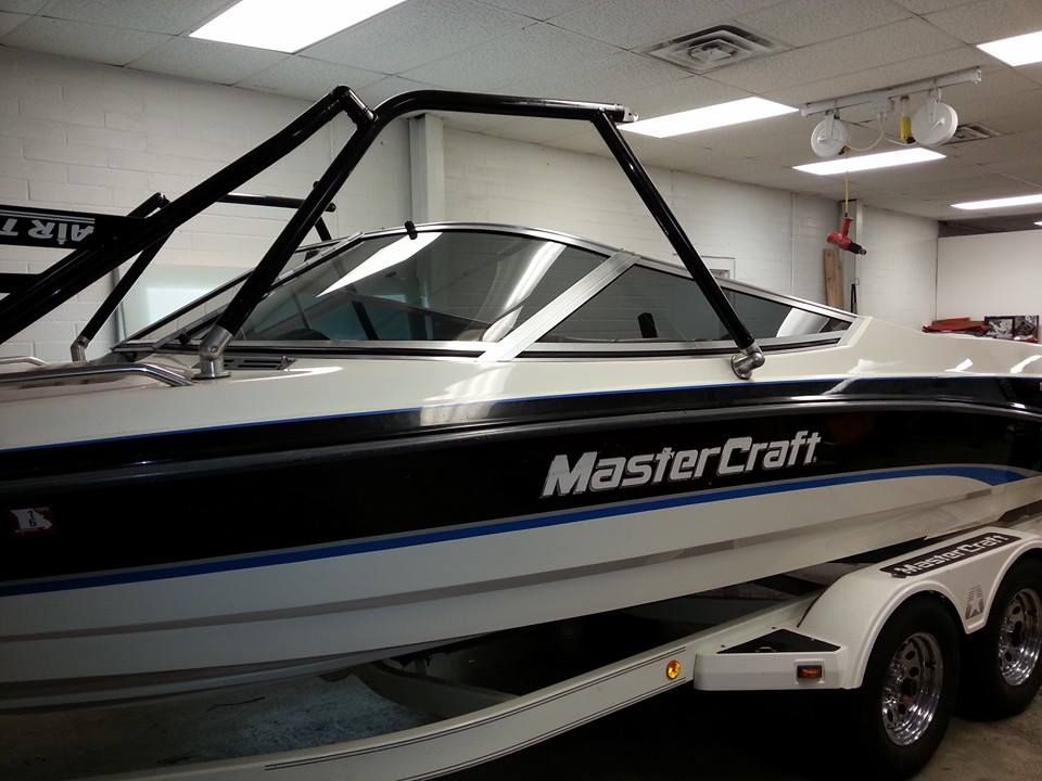 MasterCraft boat on a trailer in an indoor showroom with a black wakeboard tower