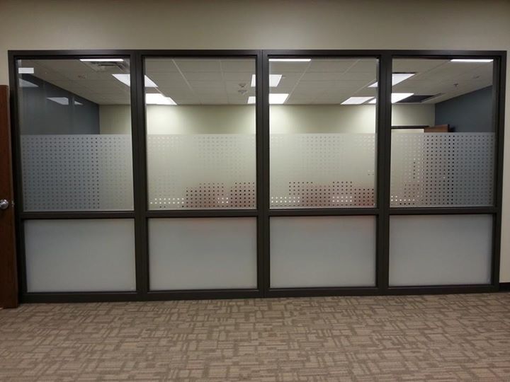 Empty office glass wall with frosted lower panels and patterned carpet floor