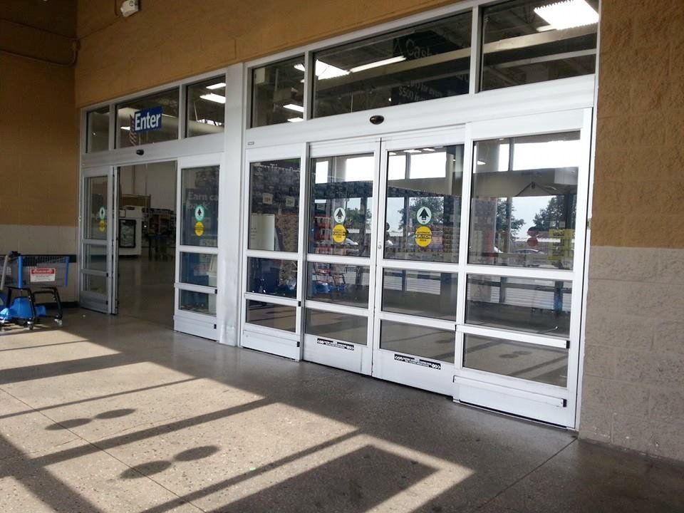 Store entrance with automatic sliding glass doors and a covered sidewalk area.