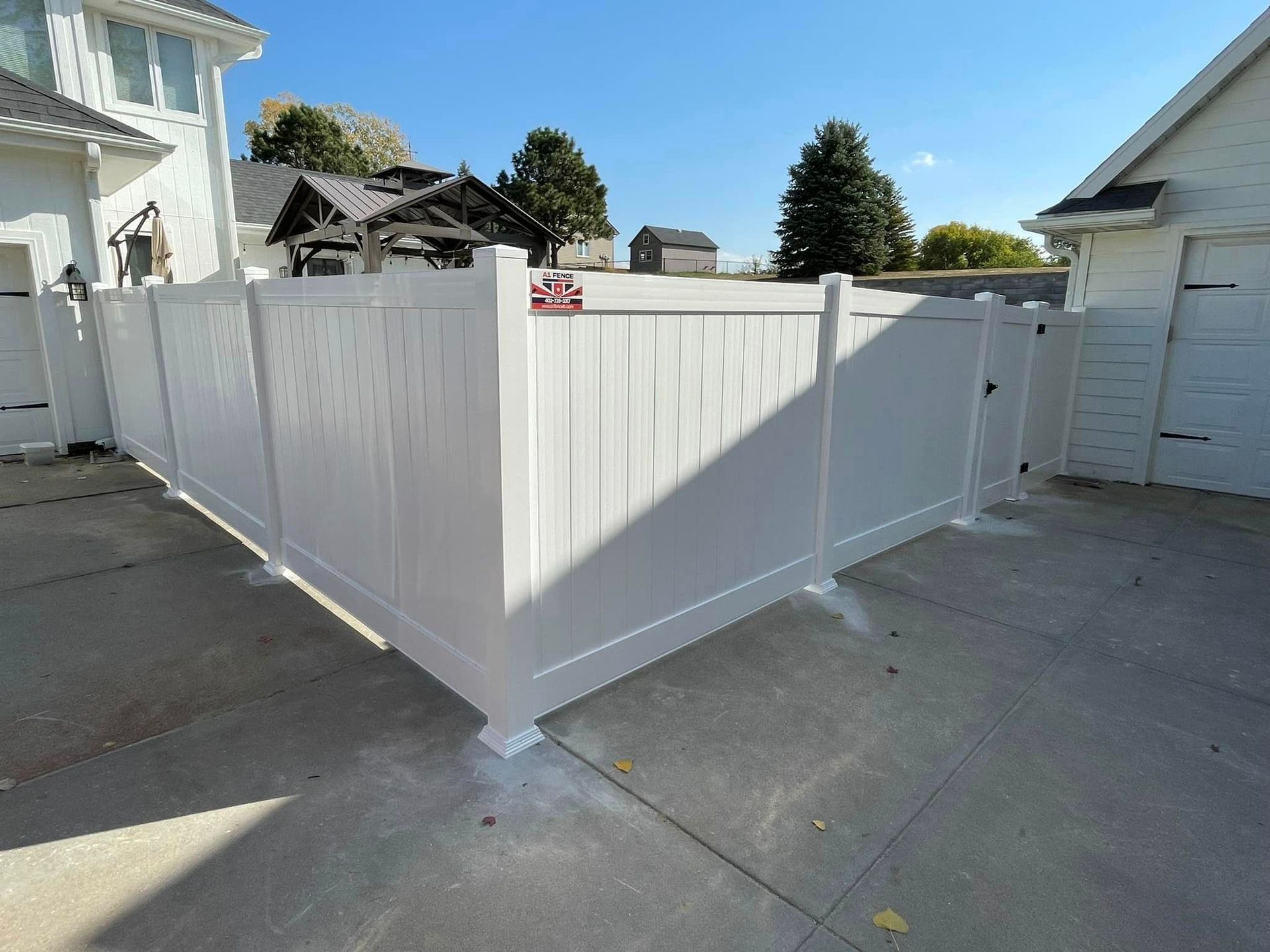 a newly-installed white vinyl fence