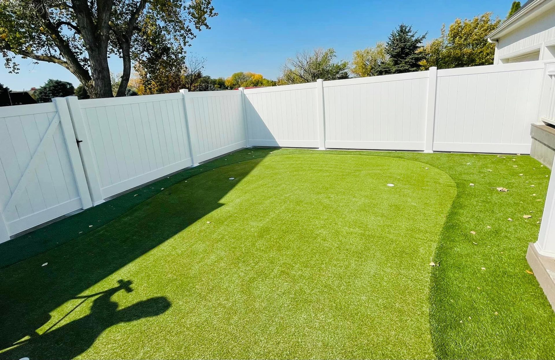 a white fence surrounds a lush green lawn