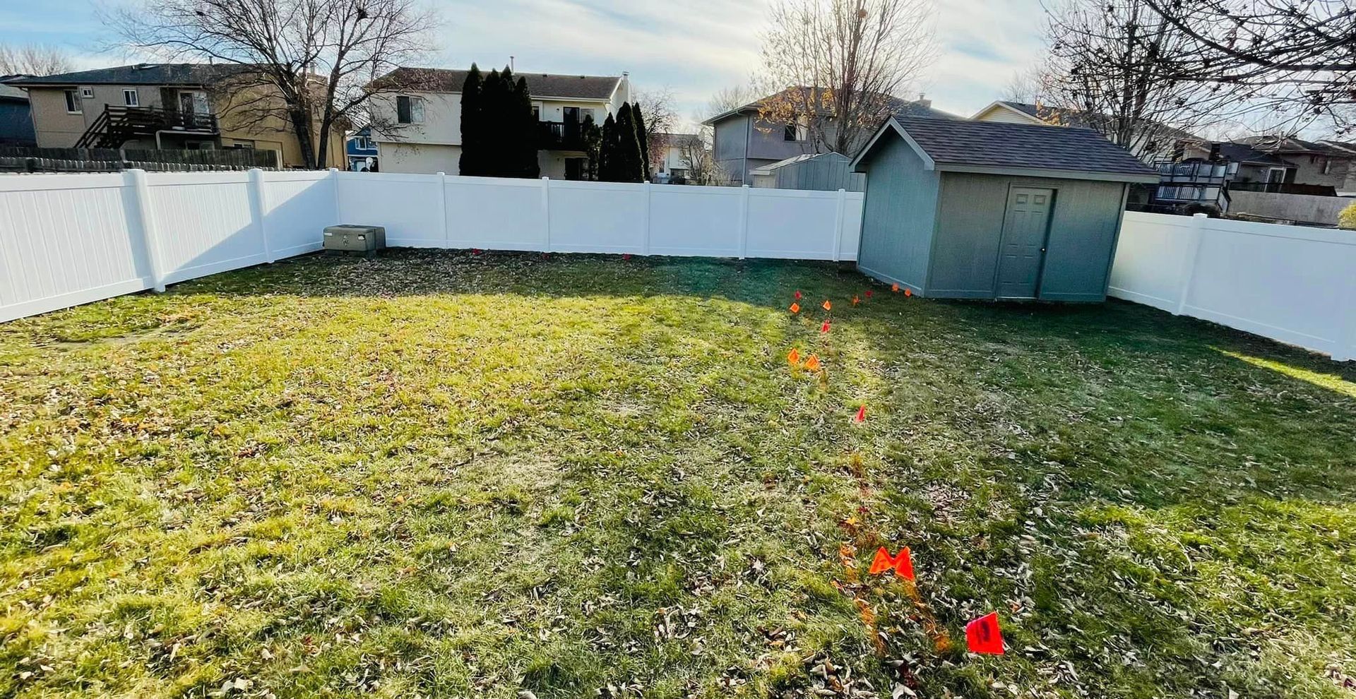 a backyard with a shed and a white fence