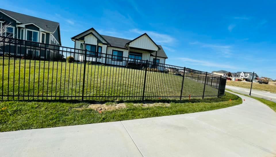 a black metal fence surrounds a house in a residential area