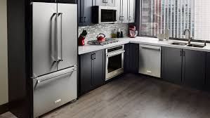A kitchen with stainless steel appliances and gray cabinets.