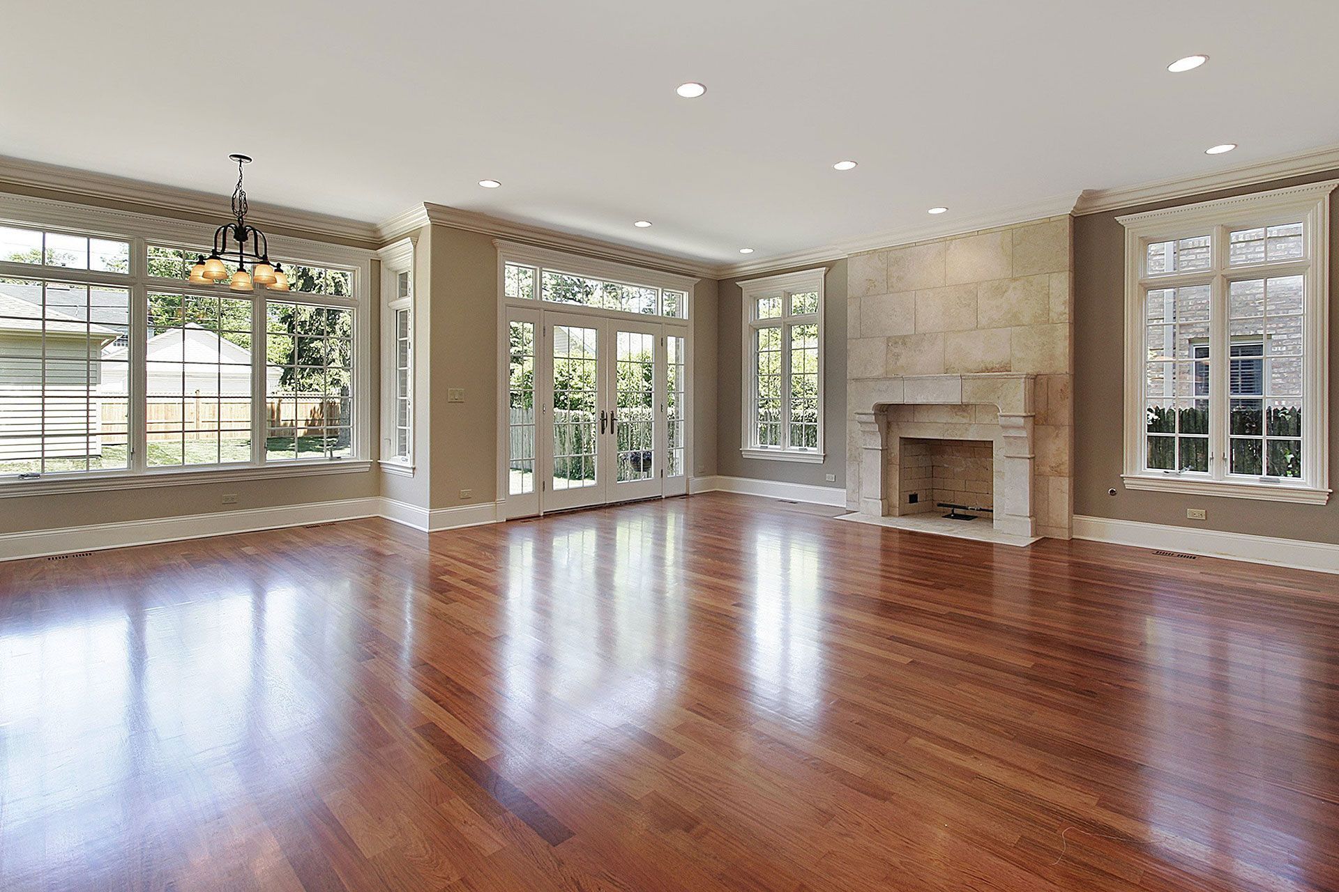 An empty living room with hardwood floors and a fireplace.