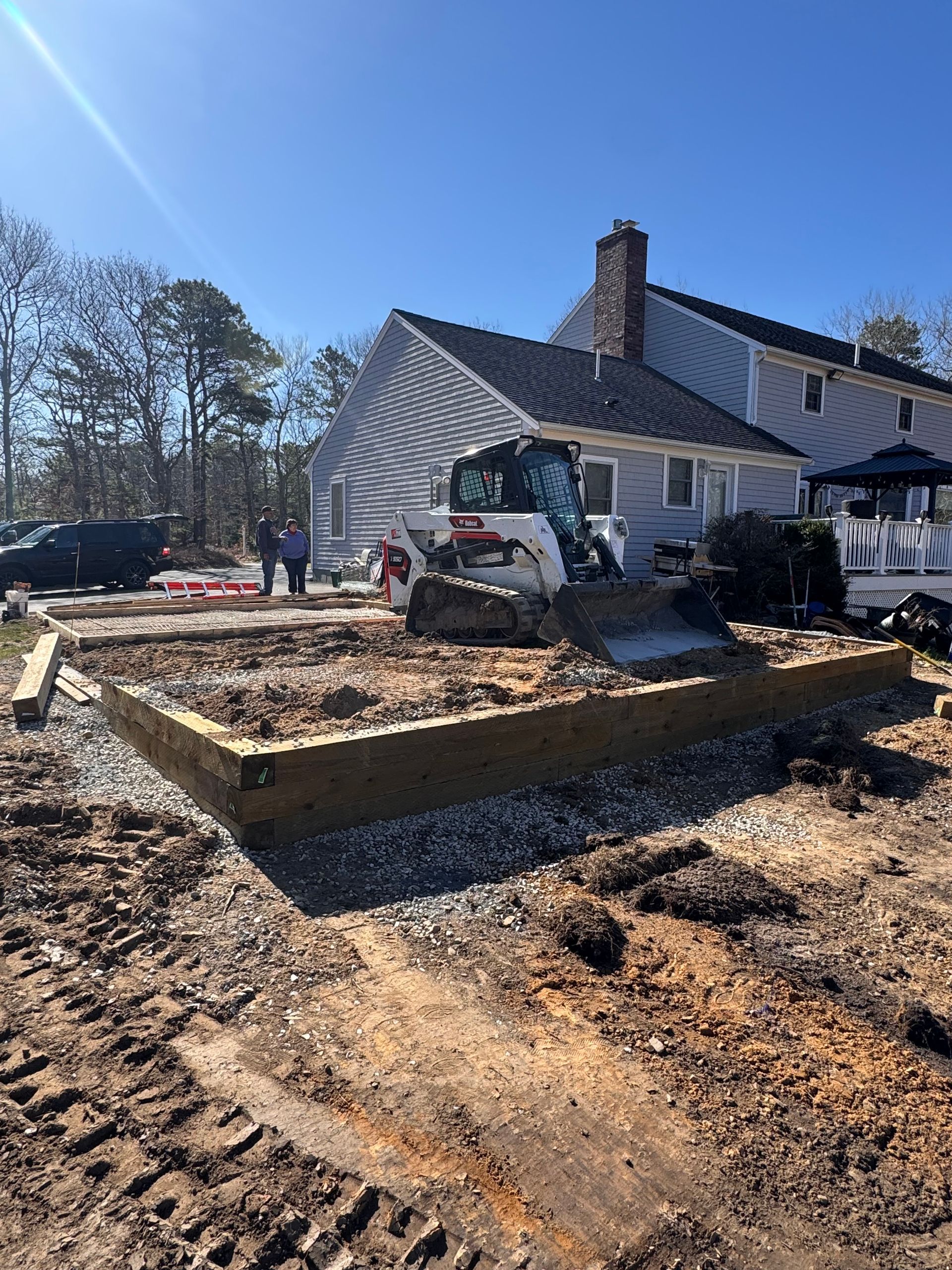 A house is being built with a bulldozer in front of it.
