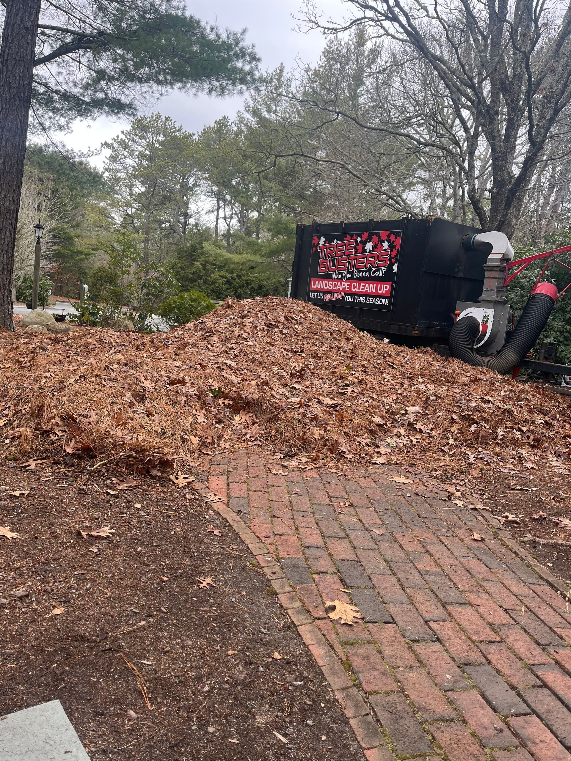 A pile of leaves is sitting on top of a brick walkway.
