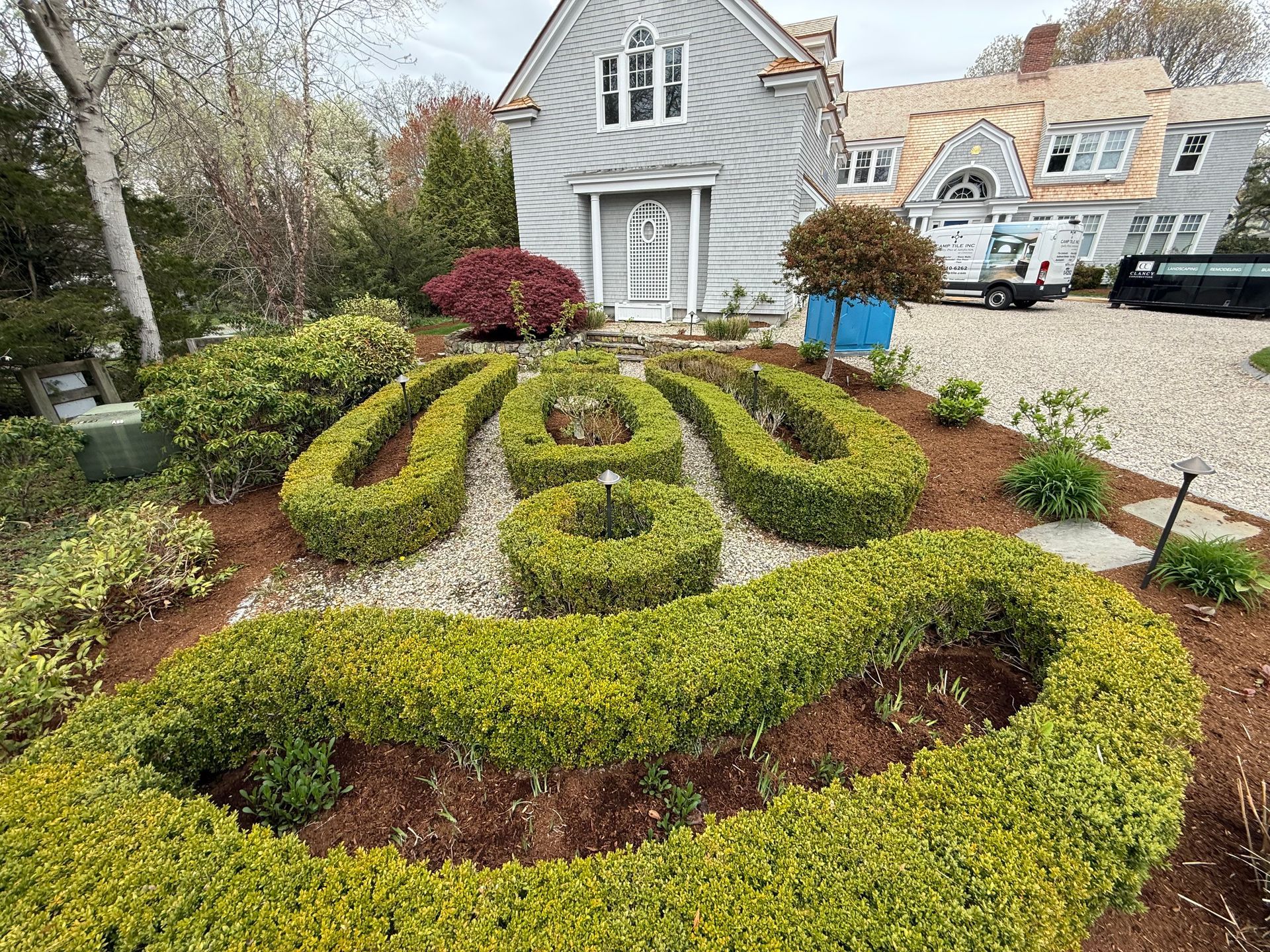 A large house with a lush green garden in front of it.