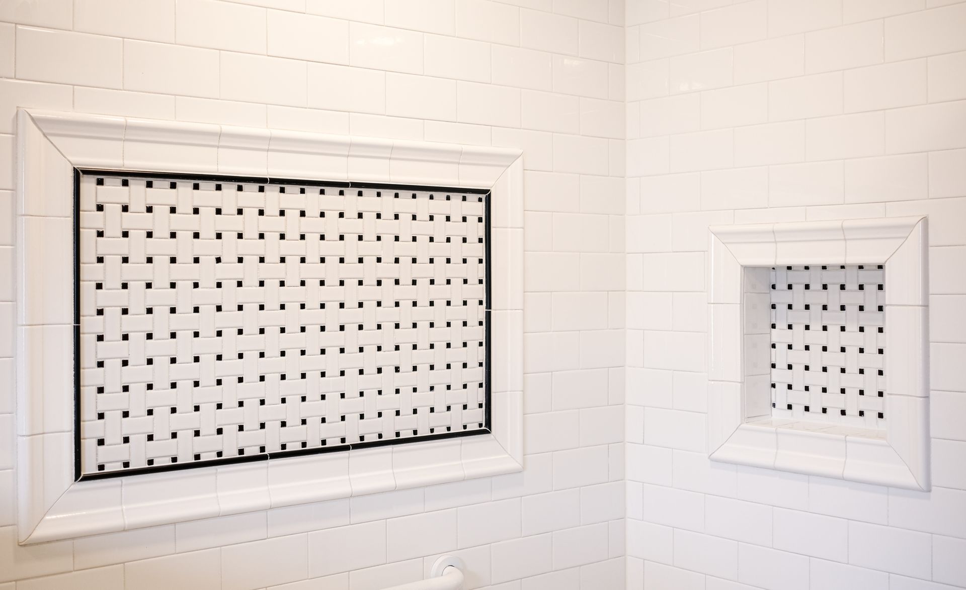 Two rectangular recessed wall niches with white tile frames and a black-and-white grid tile interior pattern.