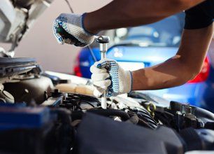 Hands of mechanic repairing the car