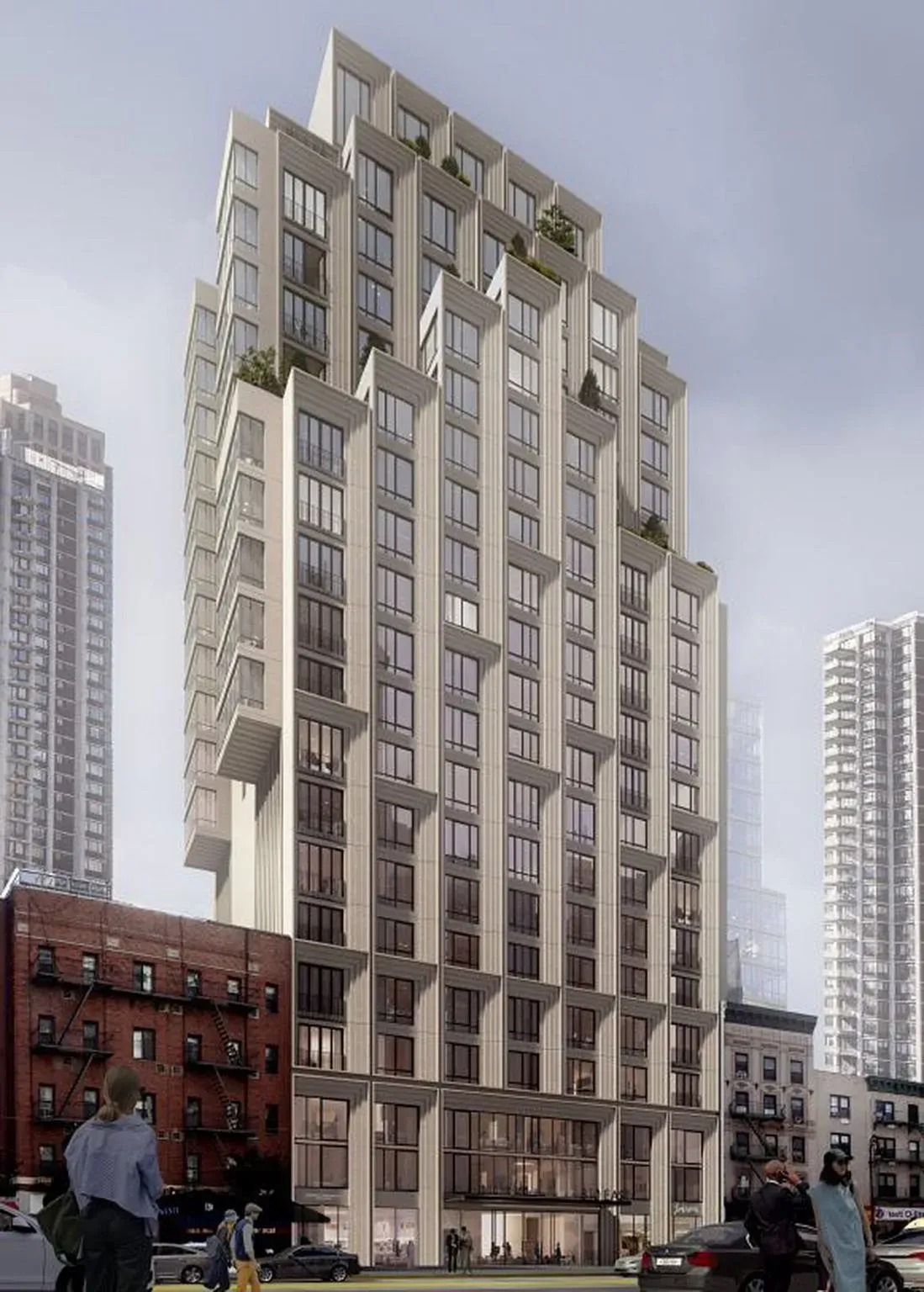 Tall modern apartment building with a stepped rooftop, viewed from the street in a city setting