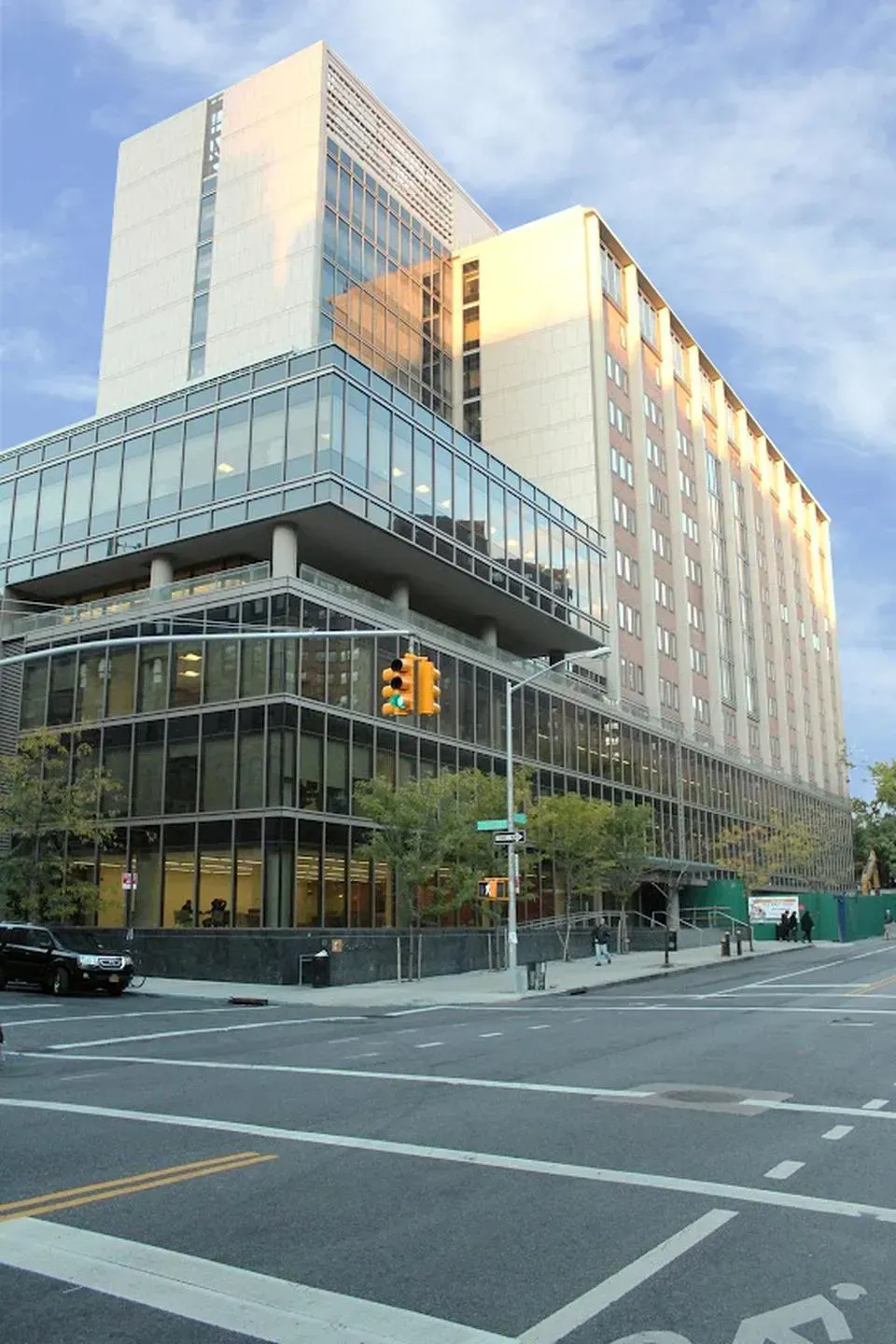 Modern glass-and-concrete office building on a city corner at sunset