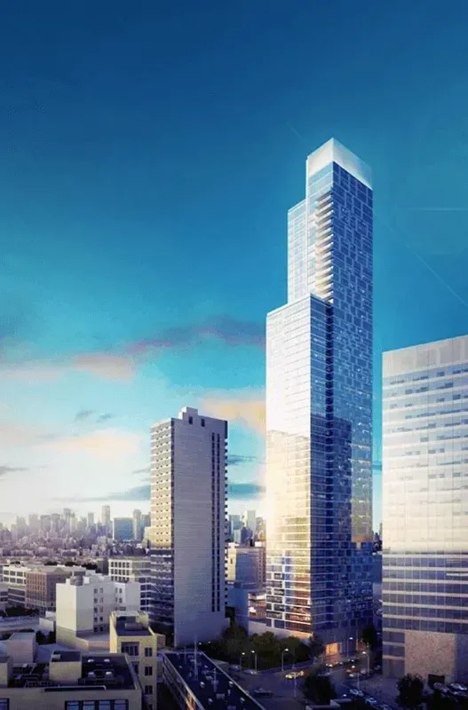 Modern glass skyscrapers in a city skyline at sunset, with a tall blue tower centered.