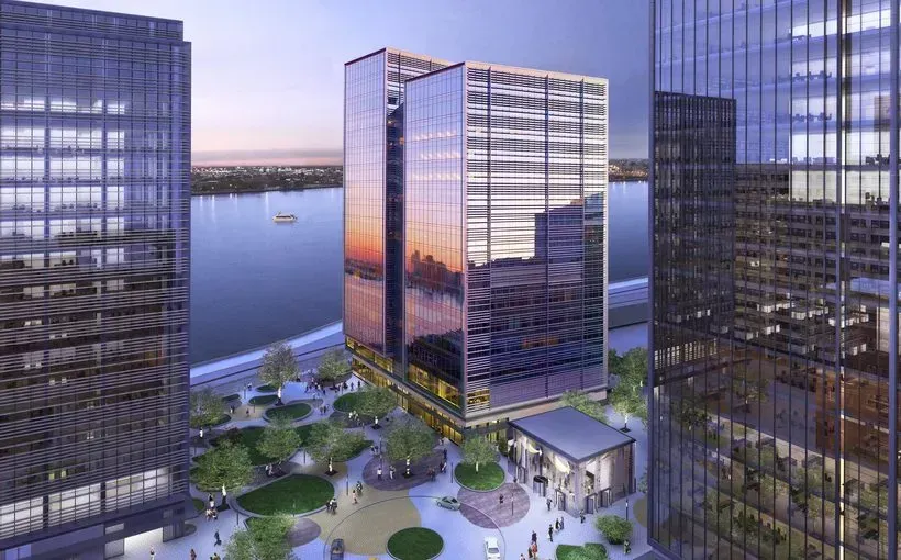 Modern waterfront office towers with a central courtyard and reflective glass at sunset