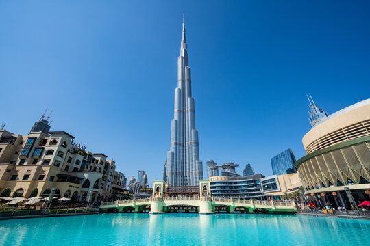 Burj Khalifa rising over a turquoise fountain pool in Dubai under a clear blue sky