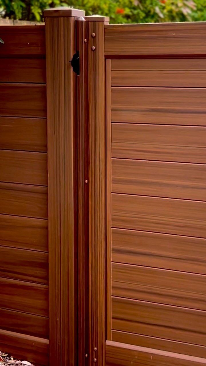 Wooden fence with gate, warm brown tones, horizontal slats.