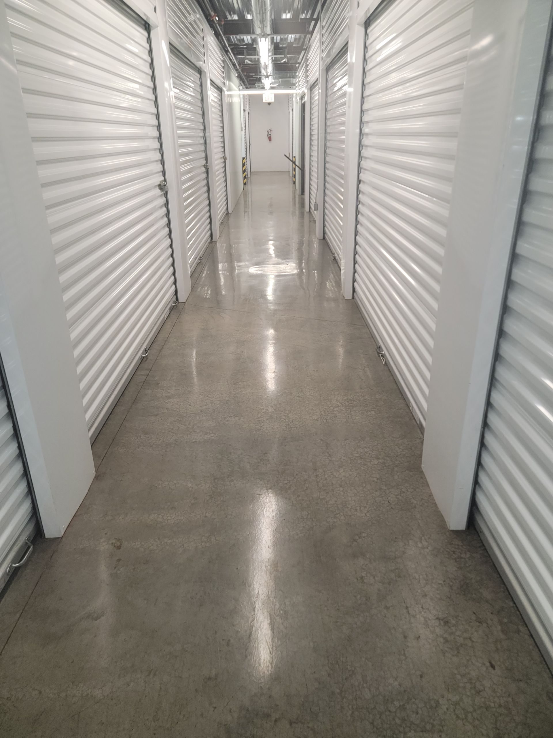 A long hallway with a lot of white walls and doors.