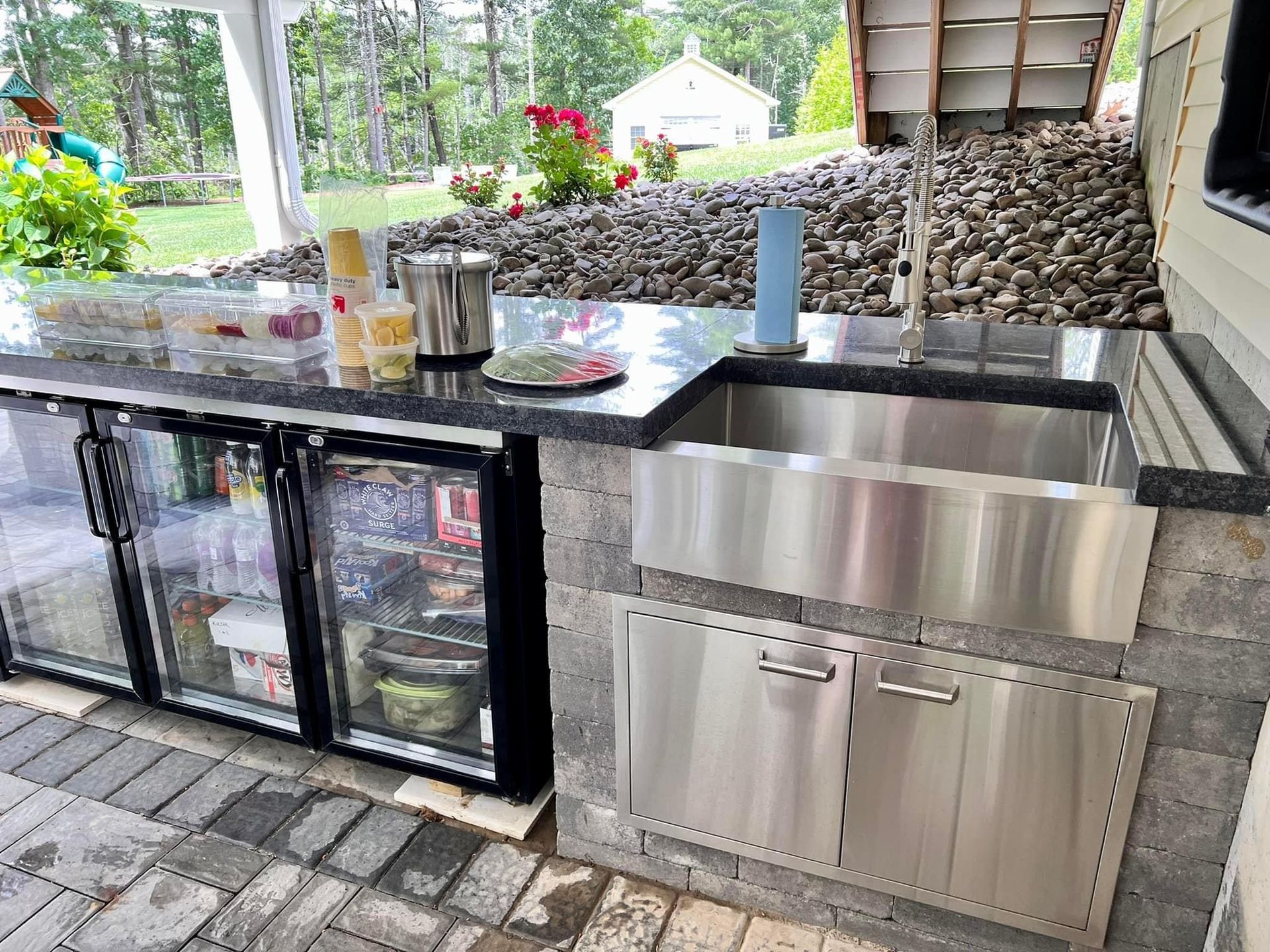 A kitchen with a stainless steel sink and a refrigerator.