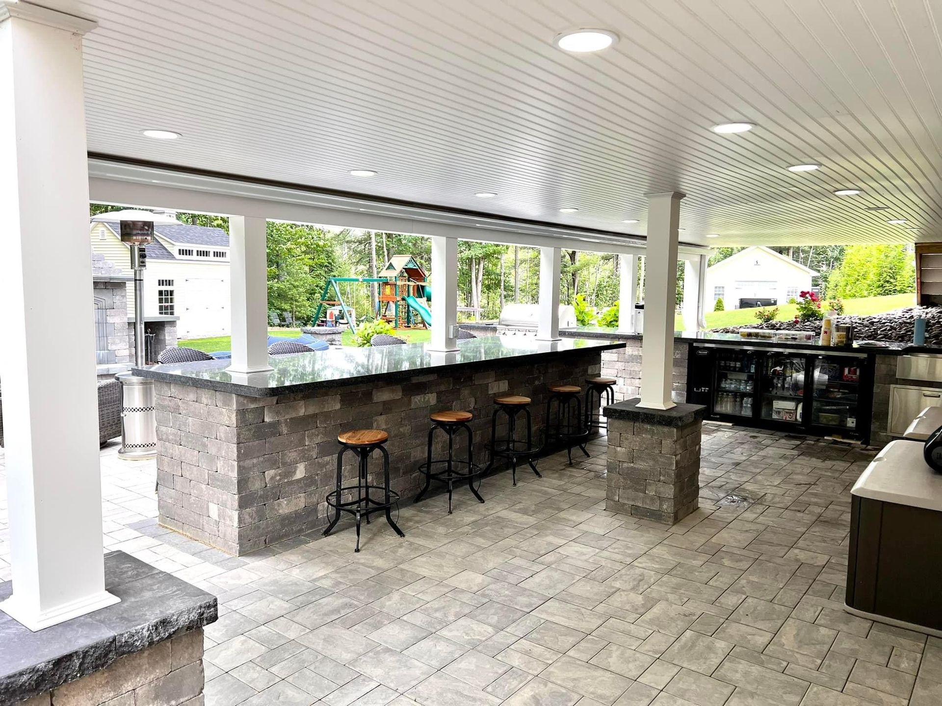 A large outdoor kitchen with a bar and stools.