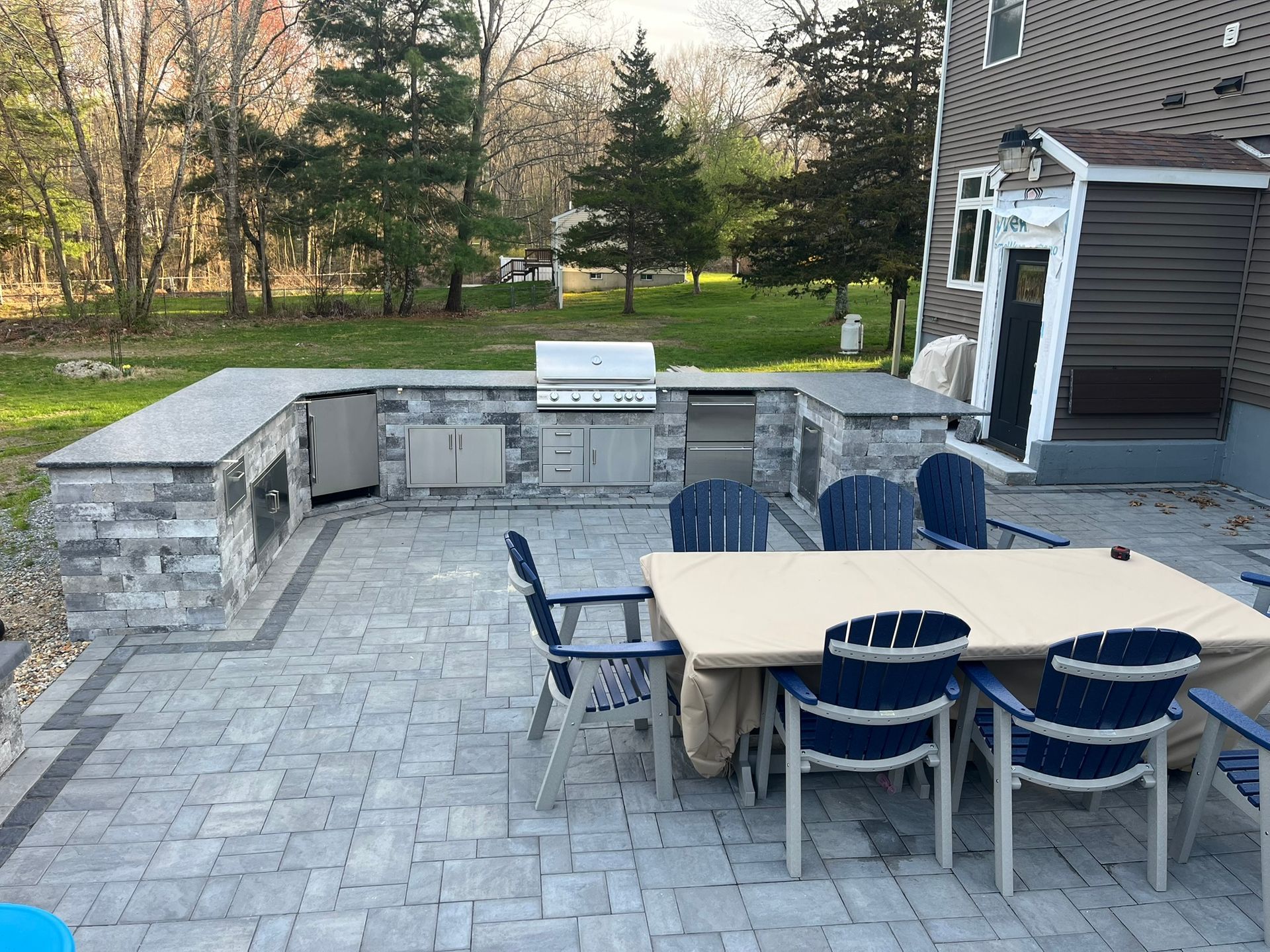 A patio with a table and chairs and a grill