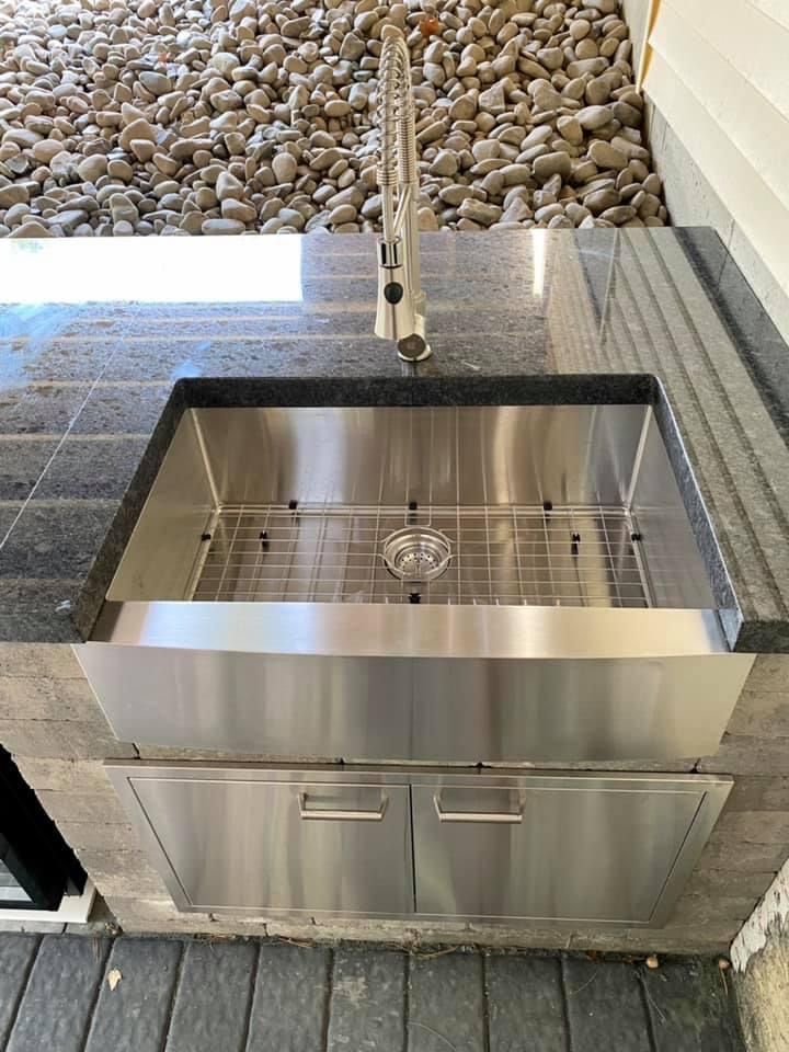 A stainless steel sink is sitting on top of a granite counter.