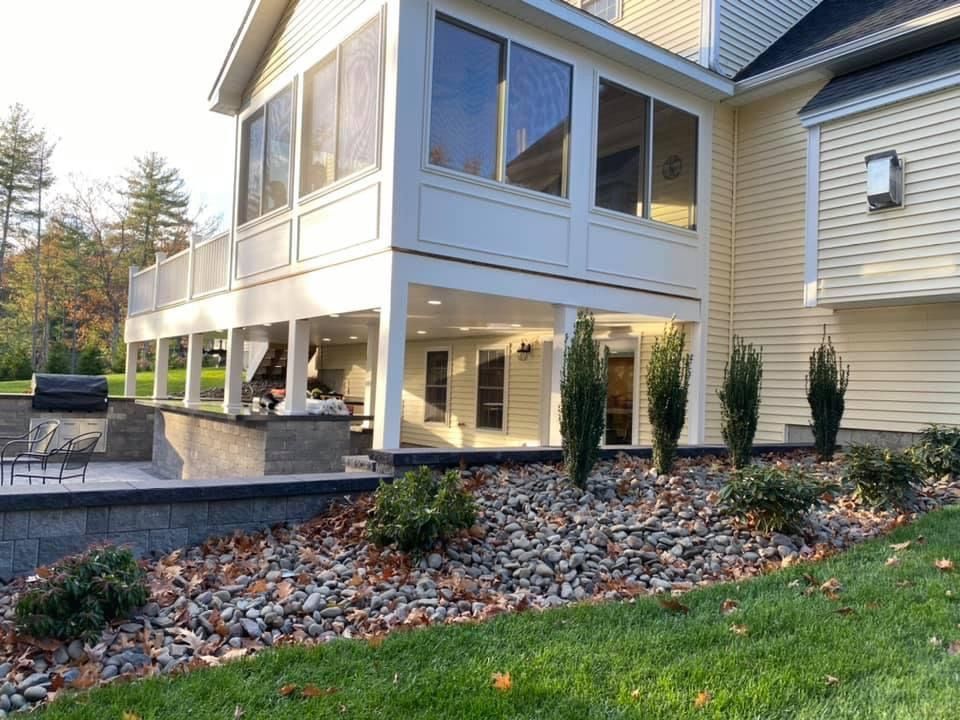 A large house with a screened in porch and a patio.