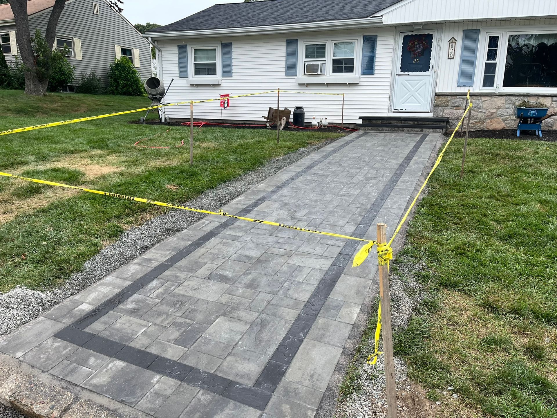 A brick walkway is being built in front of a house.