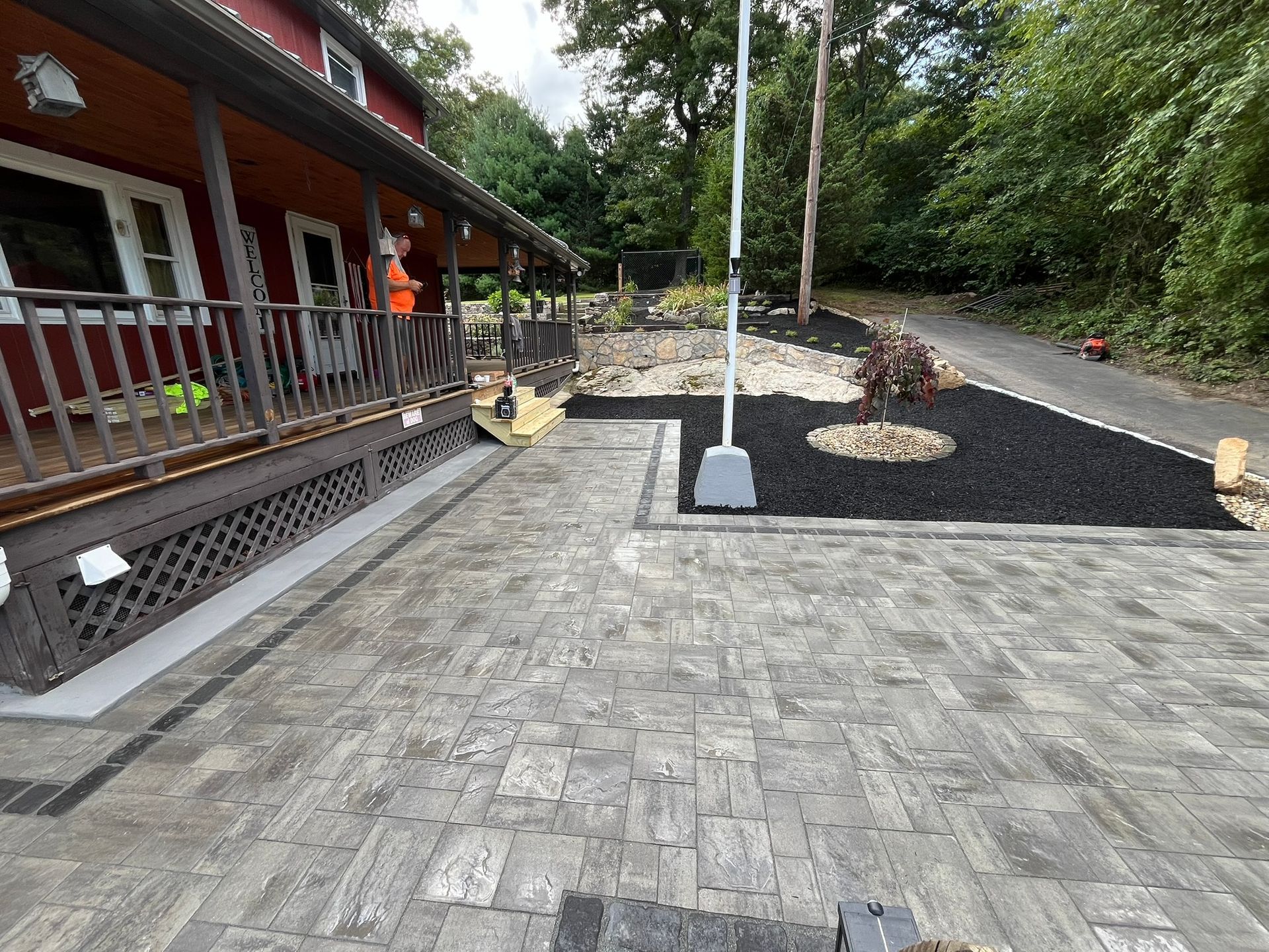 A brick patio is being built in front of a house.