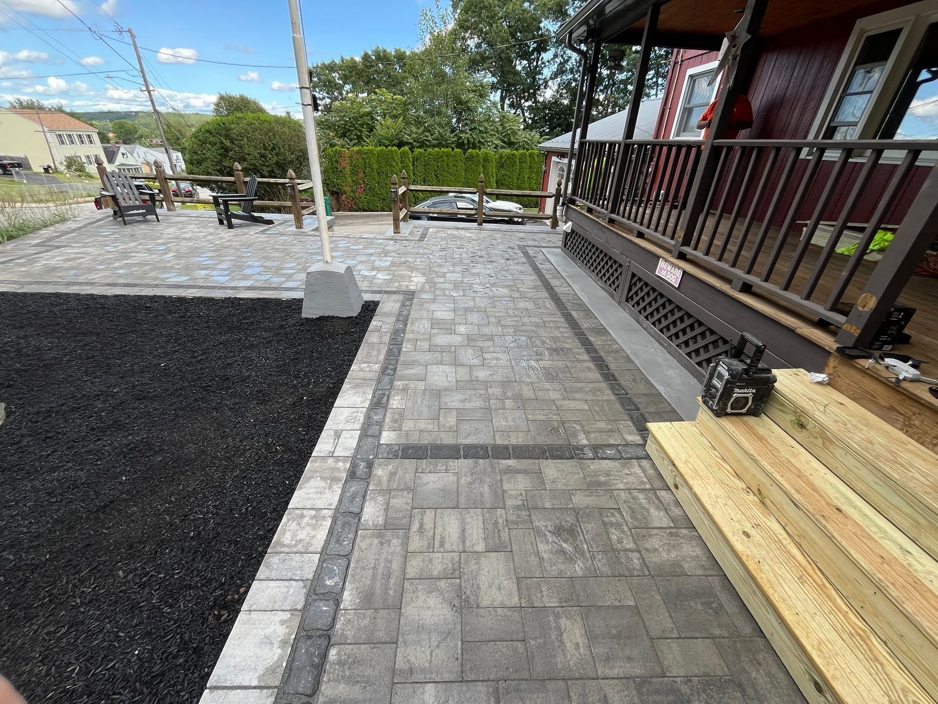 A patio with a flag pole in the middle of it and trees in the background.