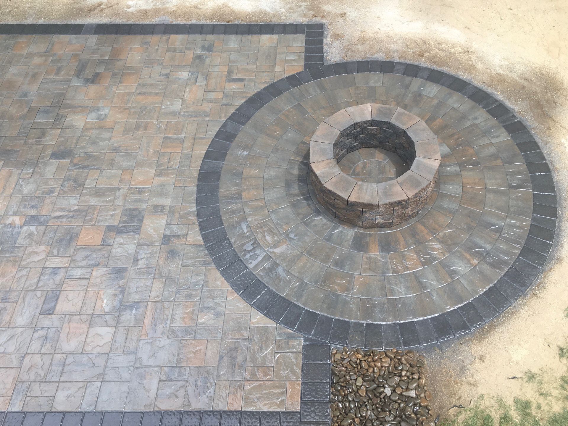 A fire pit in the middle of a brick patio