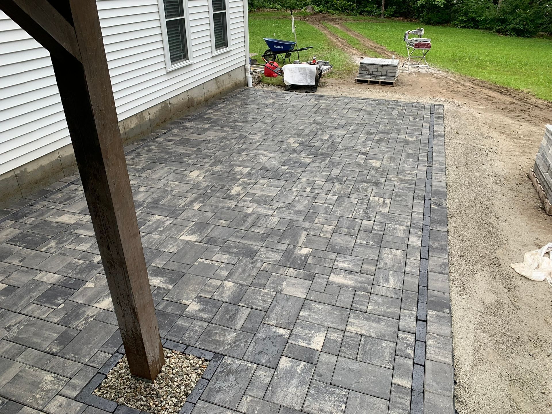 A patio is being built in front of a house.