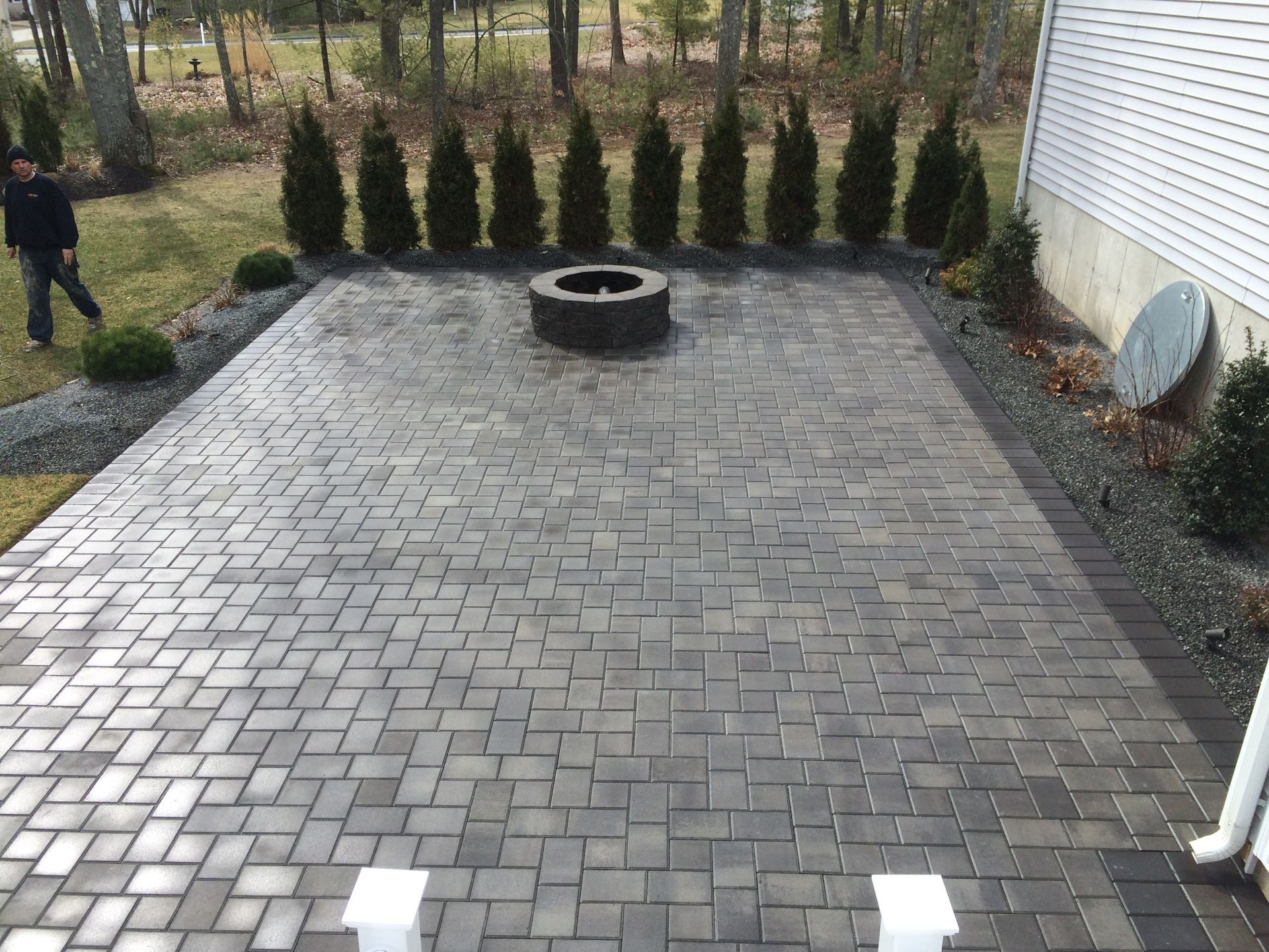 A brick patio with a fire pit in the middle