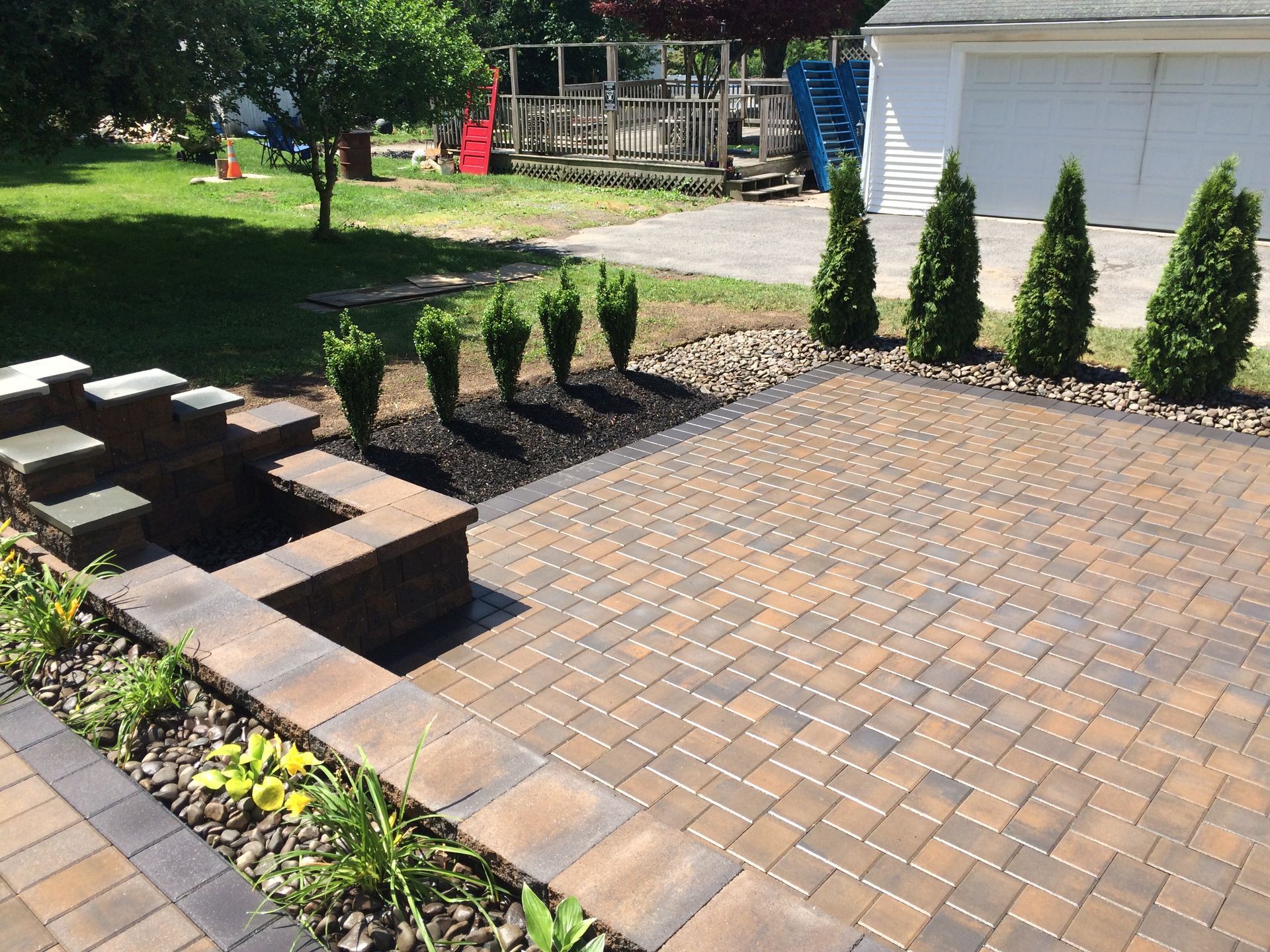 A brick patio with a fire pit in the middle of it