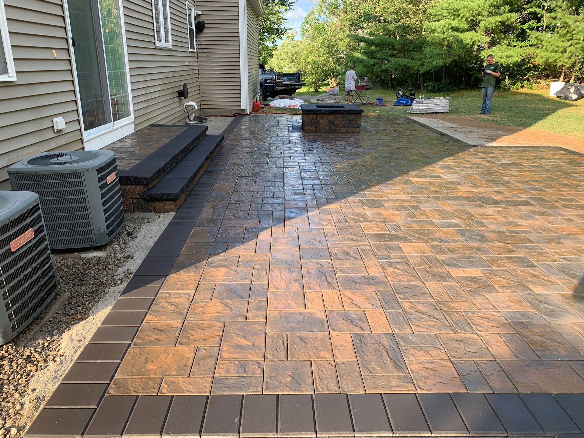 A brick walkway is being built in front of a house.