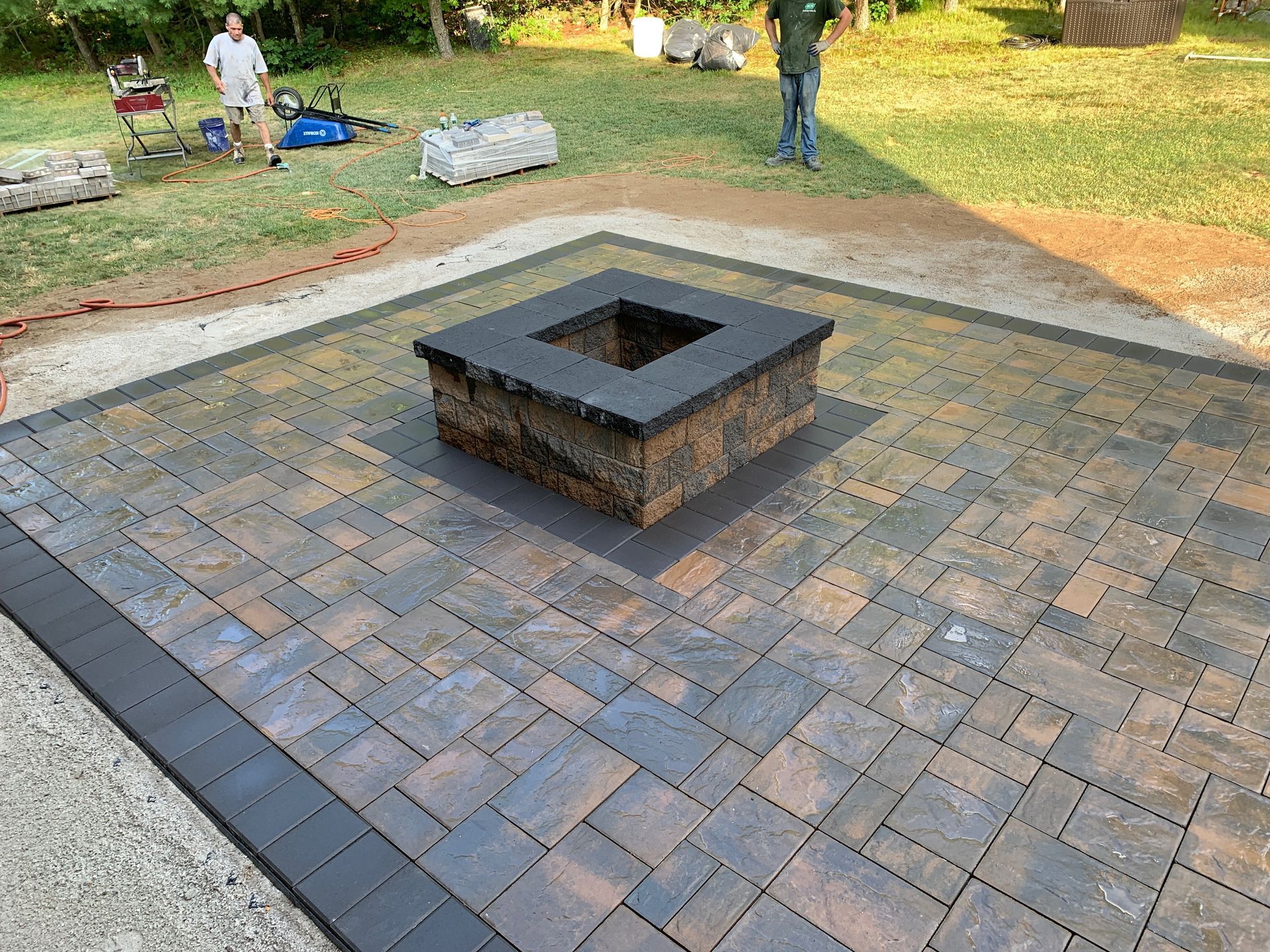A fire pit is sitting on top of a brick patio.