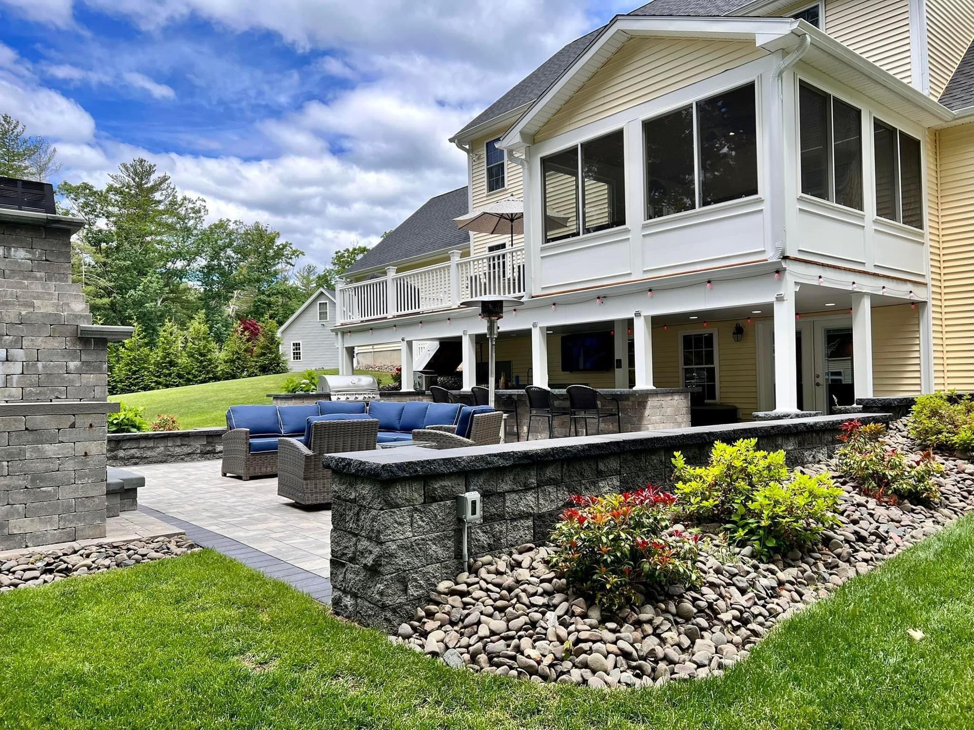 A large house with a screened in porch and patio area.