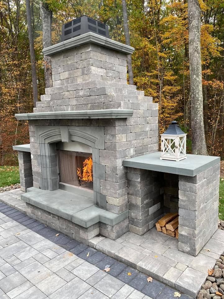 A large brick fireplace is sitting on top of a brick patio.