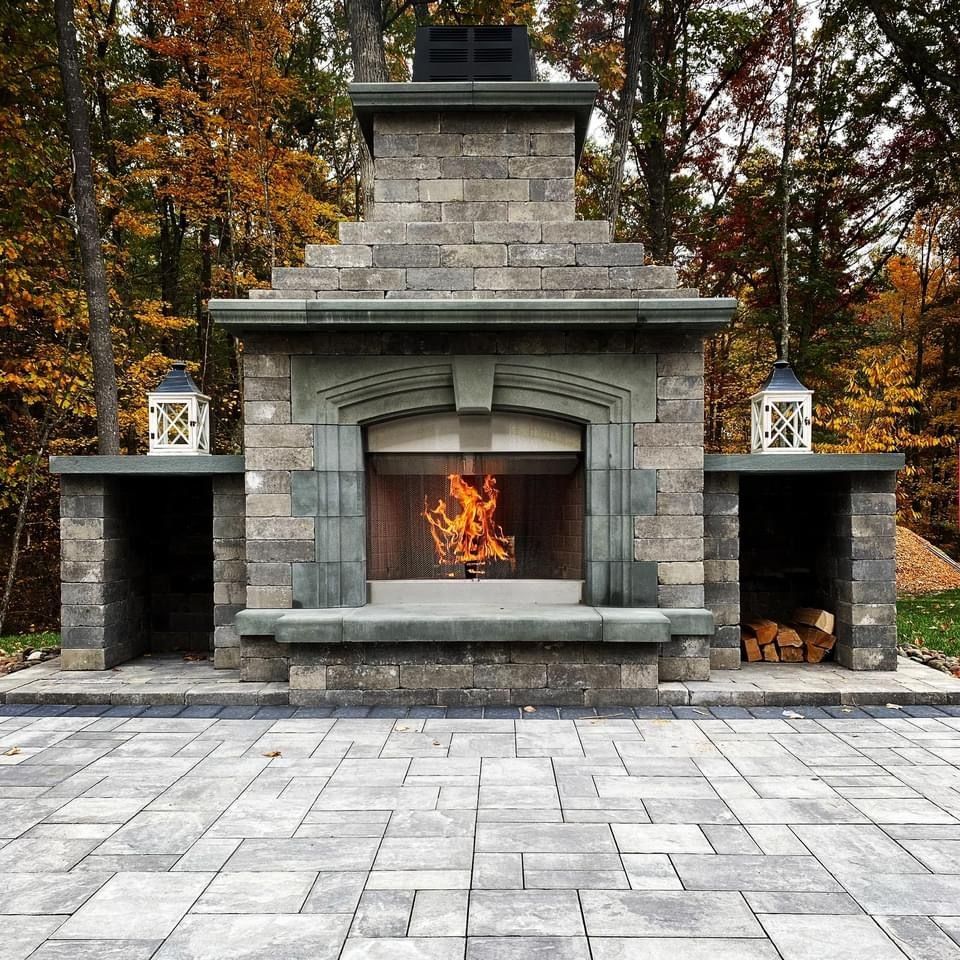 A nice-looking large brick fireplace is sitting on top of a brick patio.