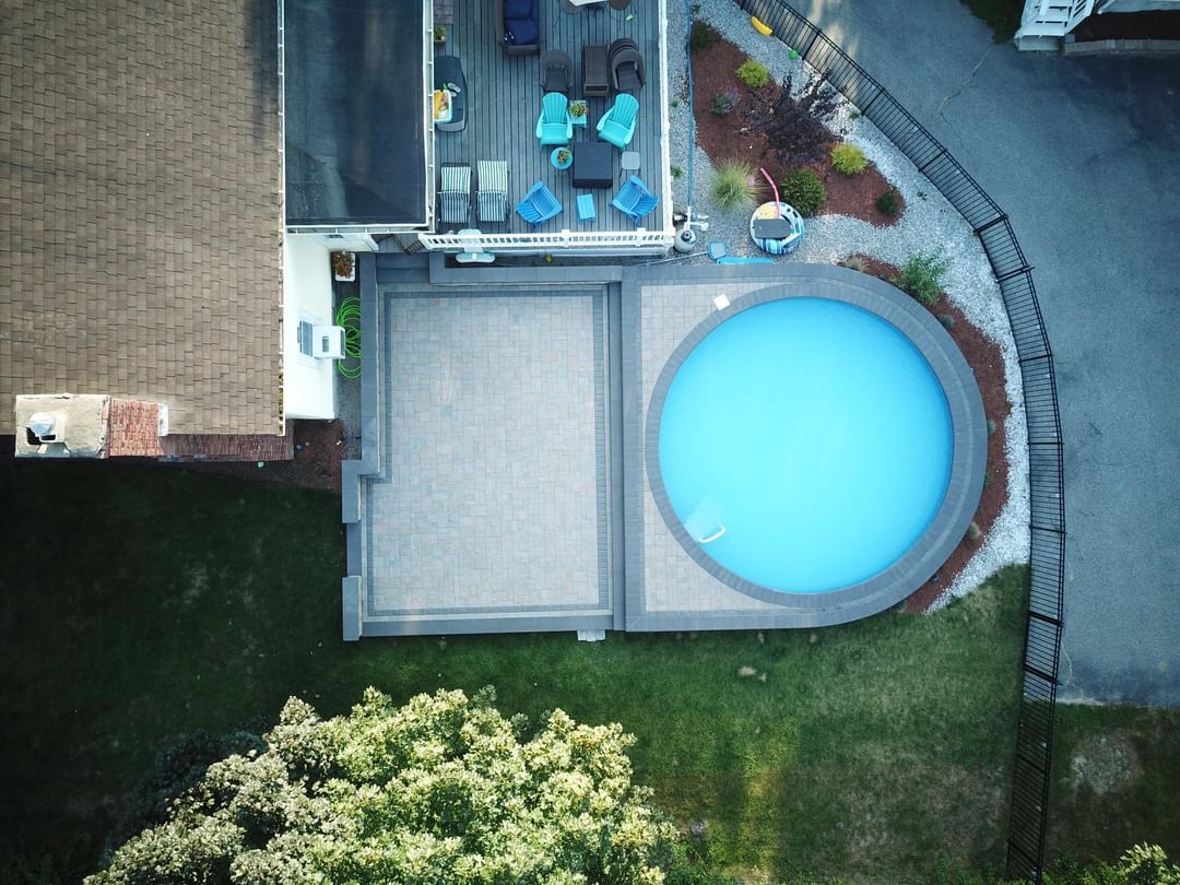 An aerial view of a swimming pool in the backyard of a house.