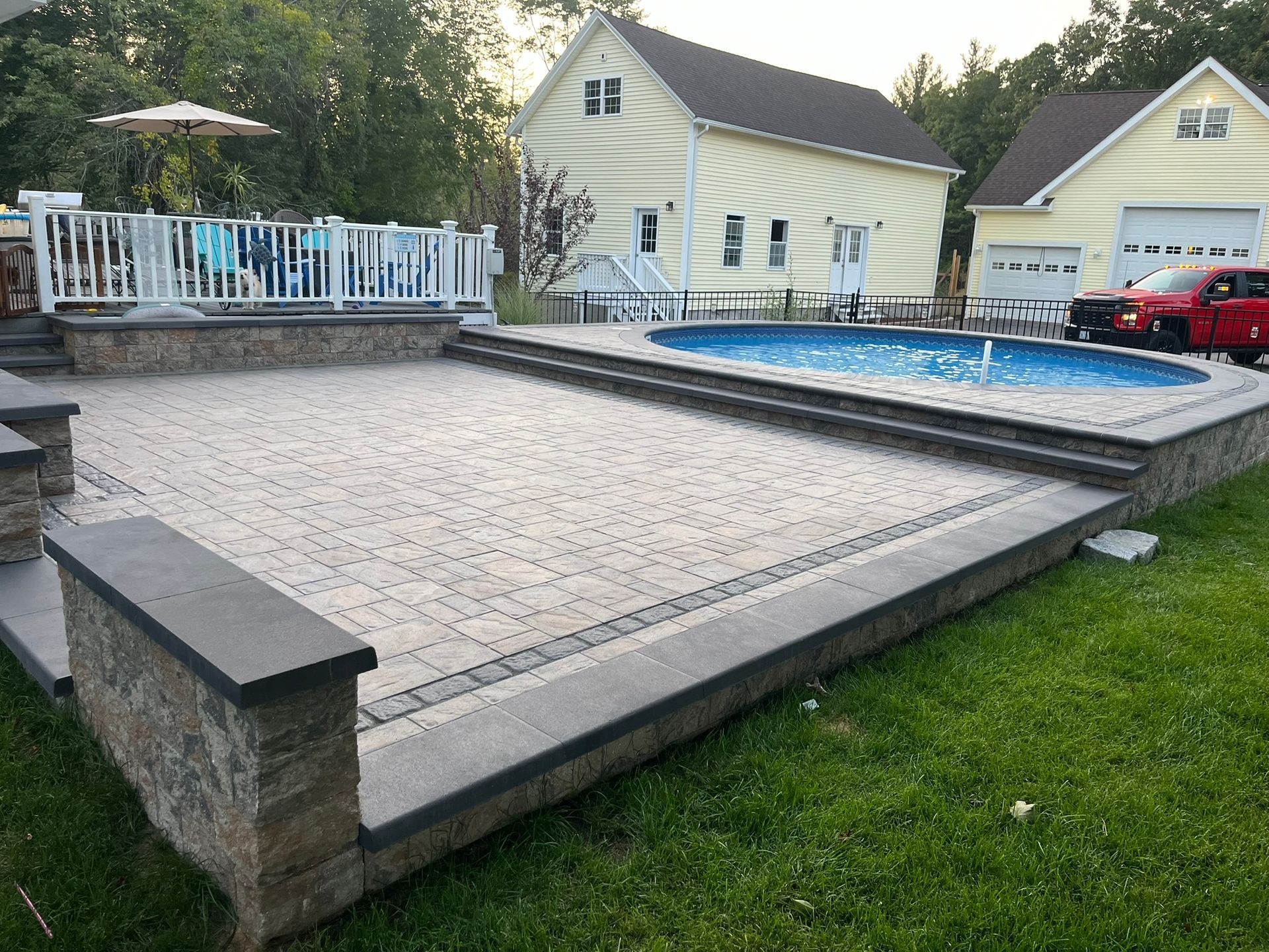 A large swimming pool is in the backyard of a house.
