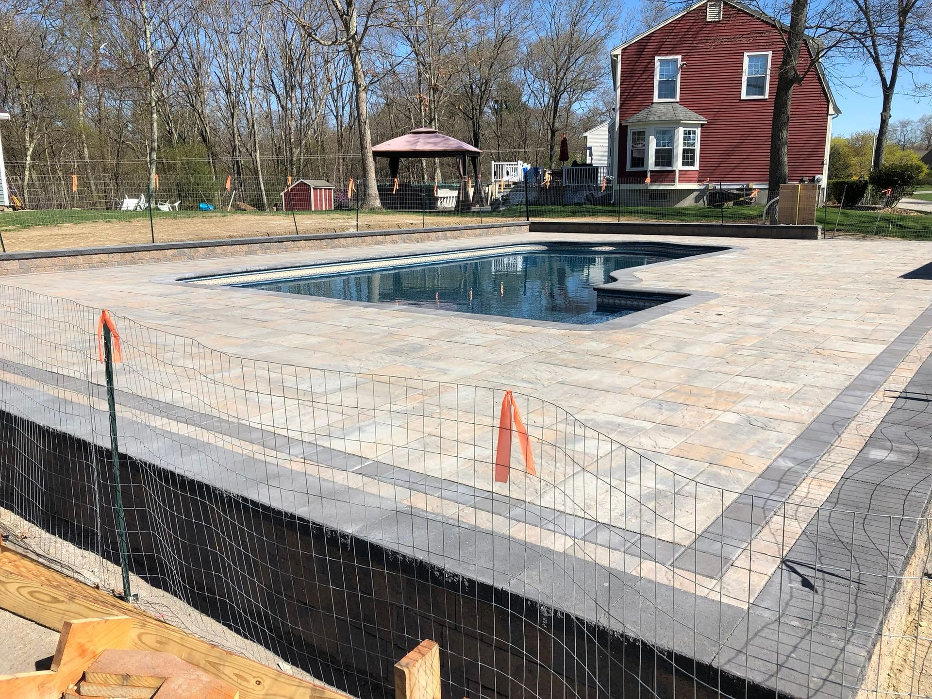 A large swimming pool is being built in the backyard of a house.