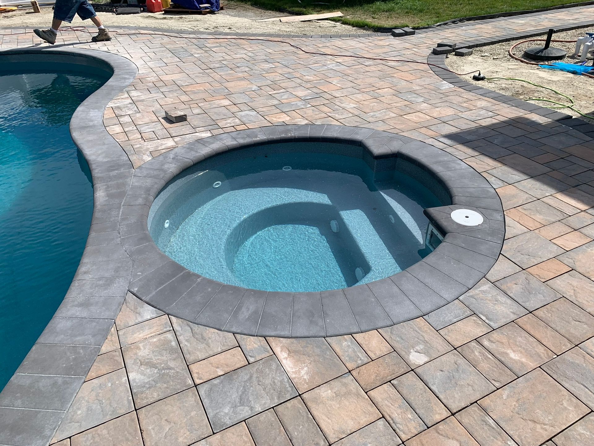 A swimming pool with a hot tub in the middle of it