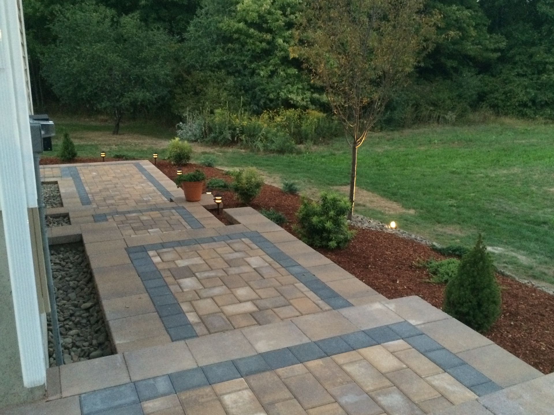 A brick walkway leading to a lush green field