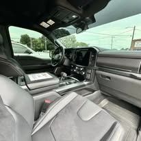 Interior view of a vehicle dashboard, steering wheel, and front seats.