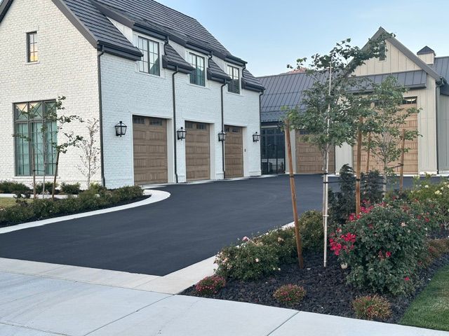 Modern suburban home with white brick facade, garage, driveway, and landscaped front garden